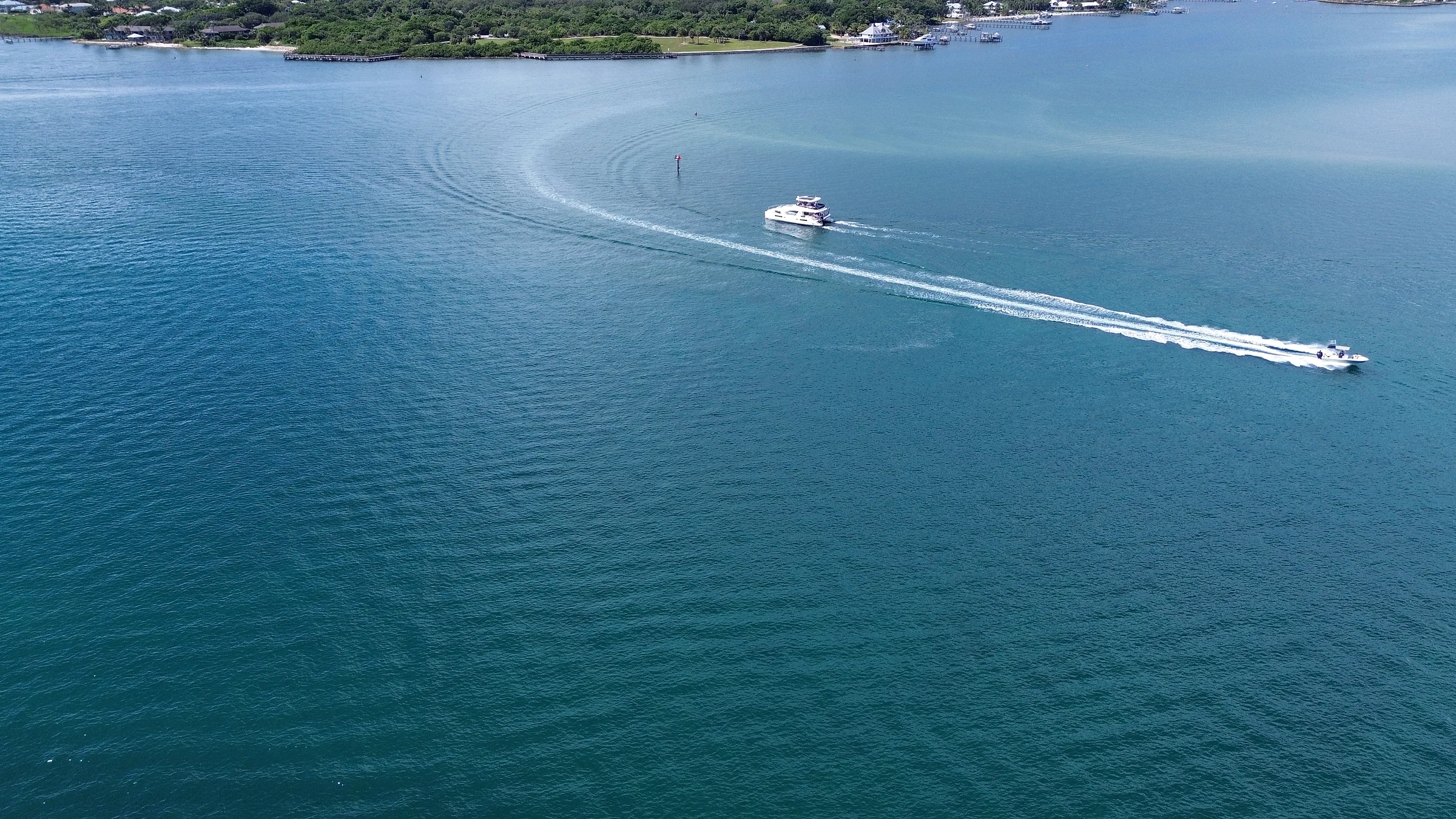 Wide aerial view of Freebird cruising through coastal water