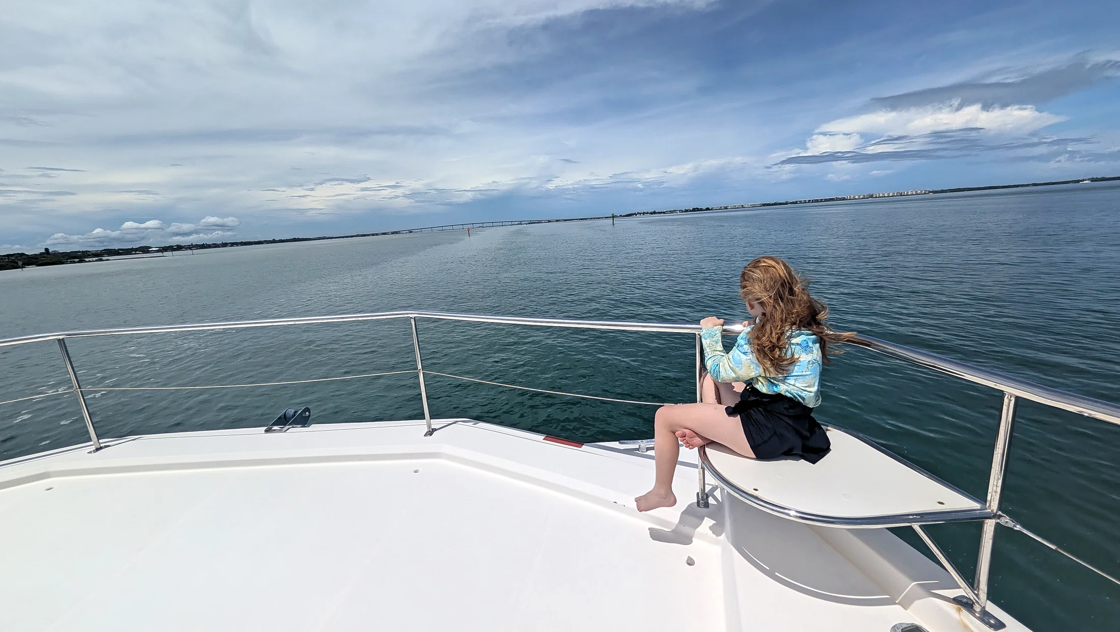 Guest relaxing on the bow of Freebird with open water ahead