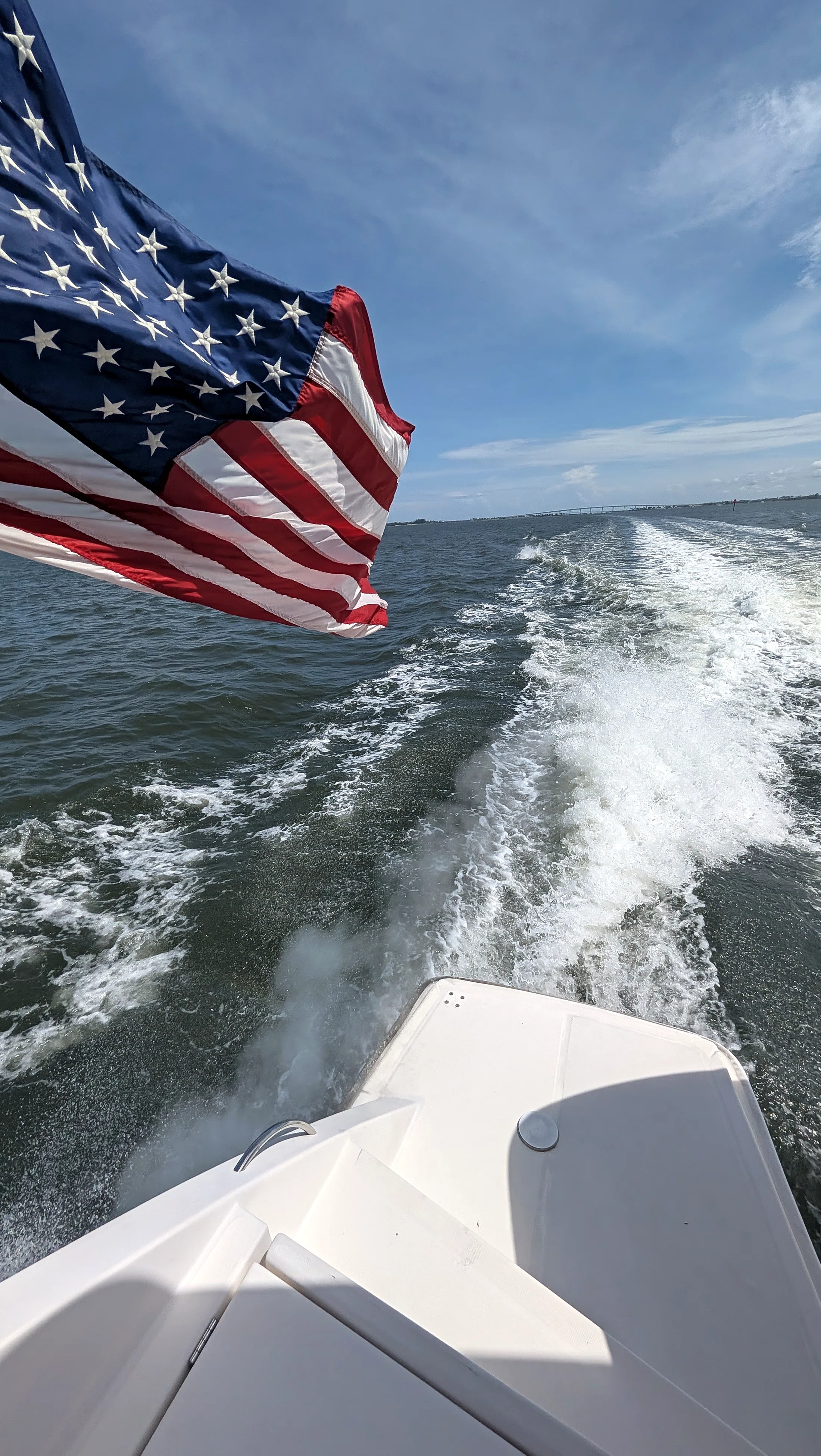 American flag flying above Freebird's wake while cruising